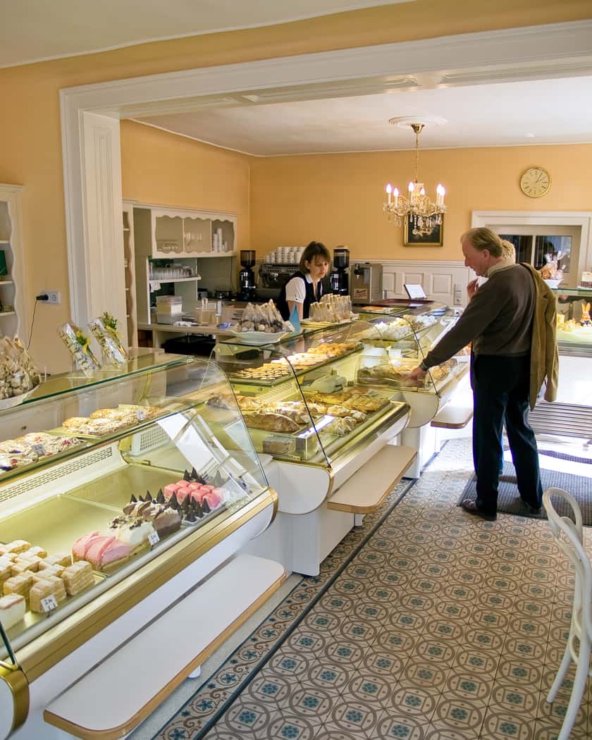 Der Verkaufsraum der Café-Konditorei Ullmann mit Vitrinen, Luster und historischem Fliesenboden