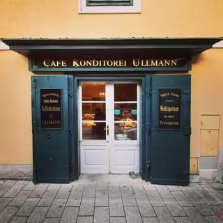 Die Ladenfront der Café-Konditorei Ullmann: goldene Lettern auf dunkelgrünen Türen
